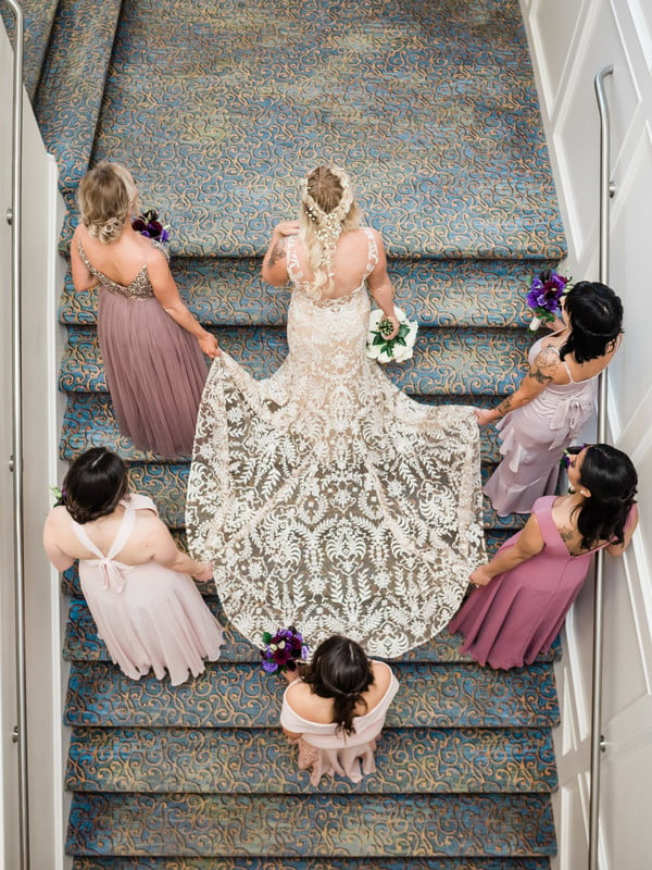 Bride with bridesmaids carrying dress train