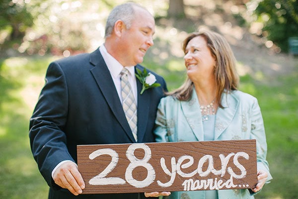 bride holding parents wedding photo