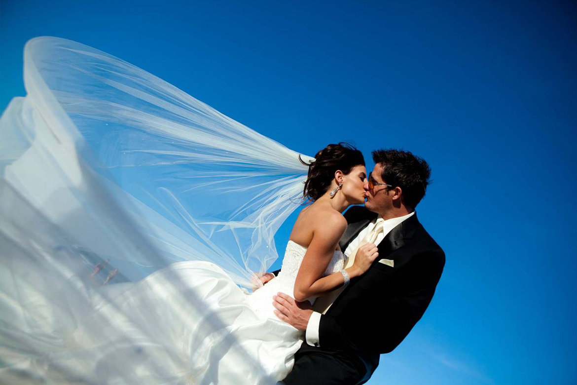 bride and groom wrapped in brides veil