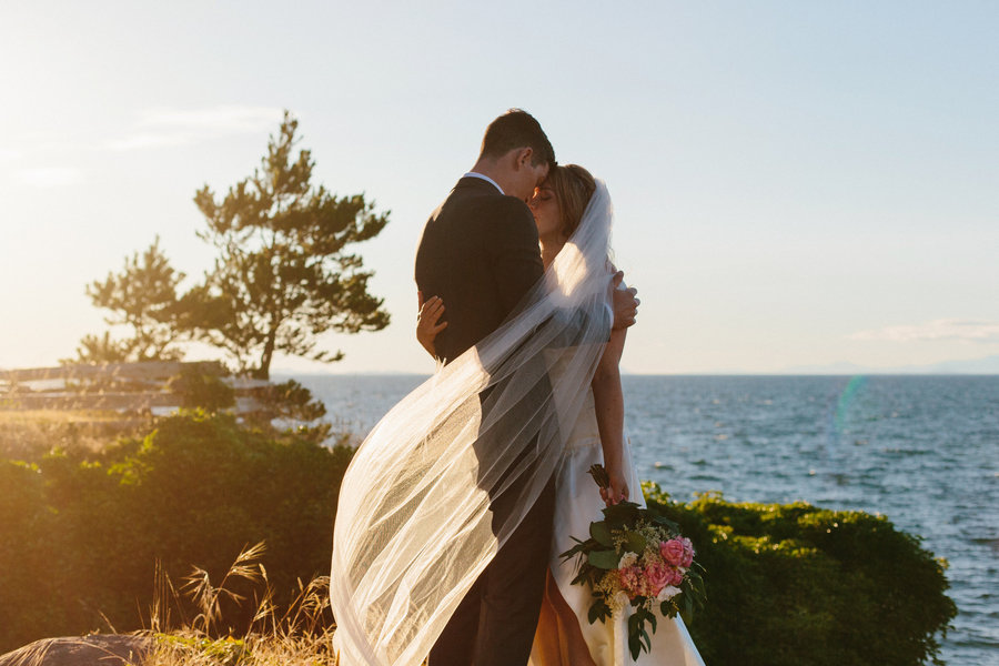 bride and groom wrapped in veil