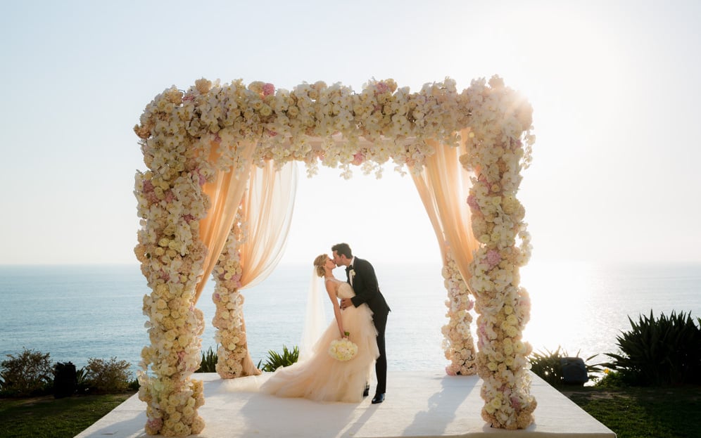 lush floral chuppah beside the sea